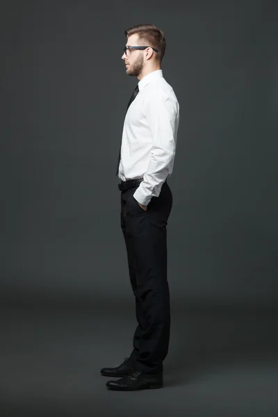 Visualizzazione del profilo di tutto il corpo del bell'uomo d'affari sul retro grigio scuro — Foto Stock