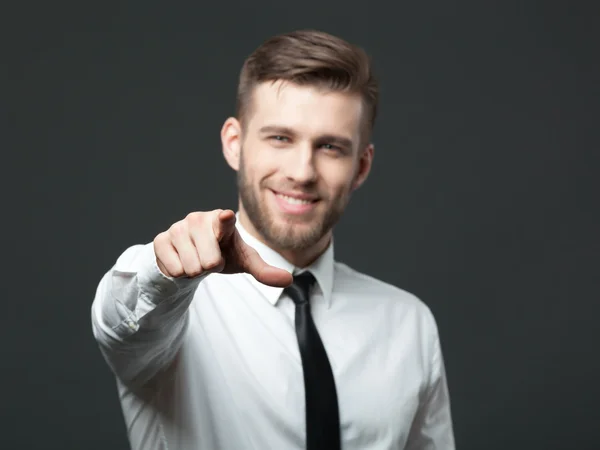 Joven hombre de negocios guapo apuntando a usted aislado en gris bac — Foto de Stock