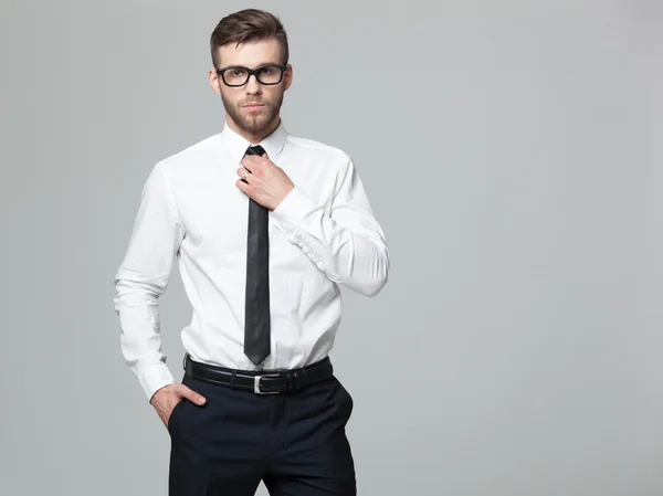 Estudio de tiro de joven hombre de negocios guapo sobre fondo gris . —  Fotos de Stock