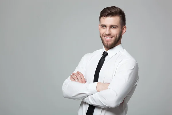 Retrato de belo jovem empresário em fundo cinza . — Fotografia de Stock