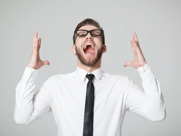 Young businessman screaming -  isolated on gray background. — Stockfoto