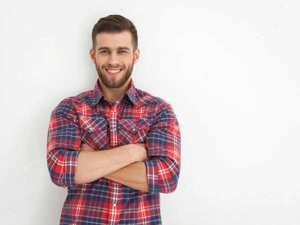 Guapo joven de pie contra la pared blanca . — Foto de Stock