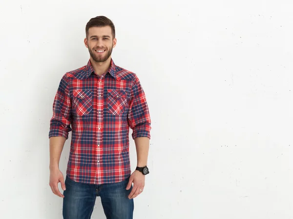 Guapo joven de pie contra la pared blanca . — Foto de Stock