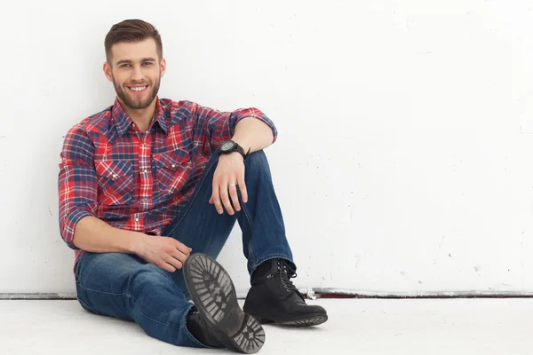 Portret van gelukkig knappe jongeman tegen de witte muur. — Stockfoto