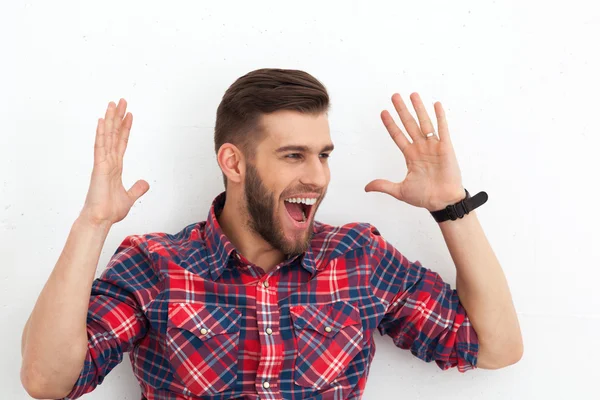 Porträt eines glücklichen, gut aussehenden jungen Mannes gegen weiße Wand — Stockfoto