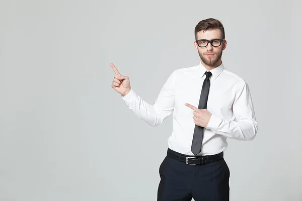 Bonito jovem empresário segurando seu braço para cima apresentando copyspa Fotos De Bancos De Imagens Sem Royalties