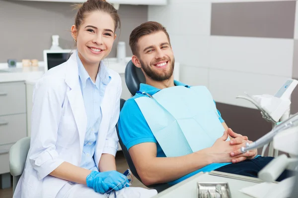 Portret kobieta dentysty i młody człowiek w gabinecie stomatologicznym. — Zdjęcie stockowe