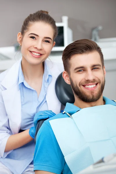 Retrato de uma dentista e um jovem em um consultório de dentista . — Fotografia de Stock