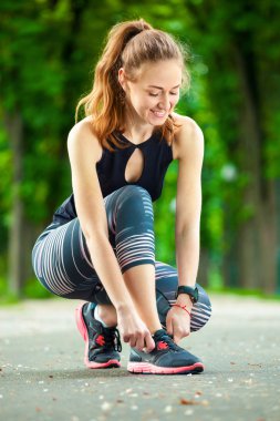 Güzel genç kadın onu dantel koşmak önce bağlama.