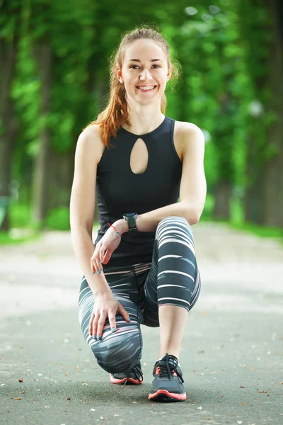 Porträt einer fröhlichen jungen Frau, die bereit ist, eine Laufeinheit zu beginnen. — Stockfoto