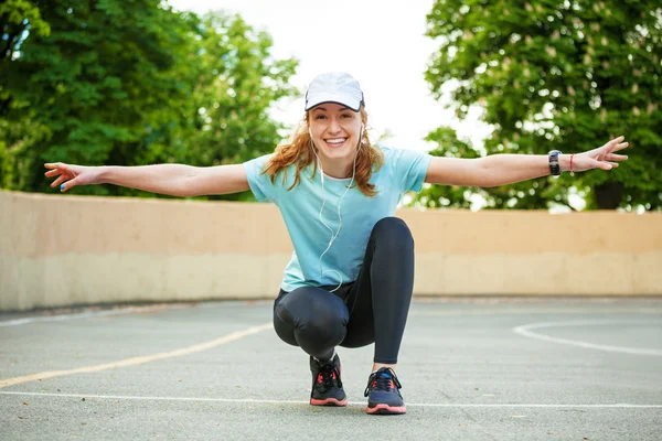 Porträt einer fröhlichen jungen Frau, die bereit ist, eine Laufeinheit zu beginnen. — Stockfoto