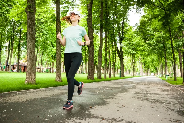 Ganzkörperporträt einer Läuferin, die im Park läuft. — Stockfoto