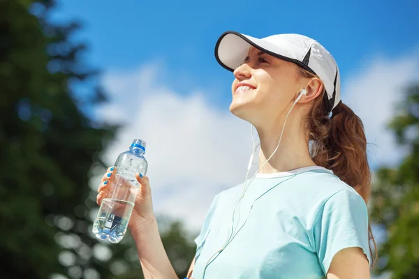 Portrait of happy fitness woman drinking water after workout. — Stock Photo, Image