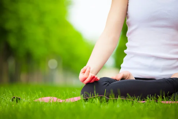 Giovane donna che fa yoga nel parco. — Foto Stock