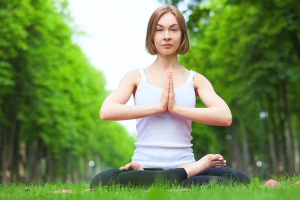 Junge Frau macht Yoga im Park. — Stockfoto