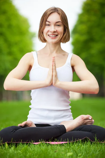 Giovane donna che fa yoga nel parco. — Foto Stock