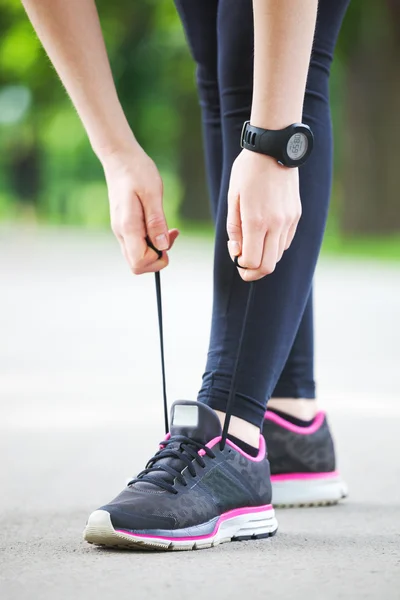 Молодая женщина завязывает шнурки перед пробежкой . — стоковое фото