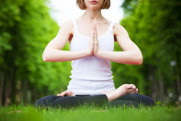 Giovane donna che fa yoga nel parco. — Foto Stock