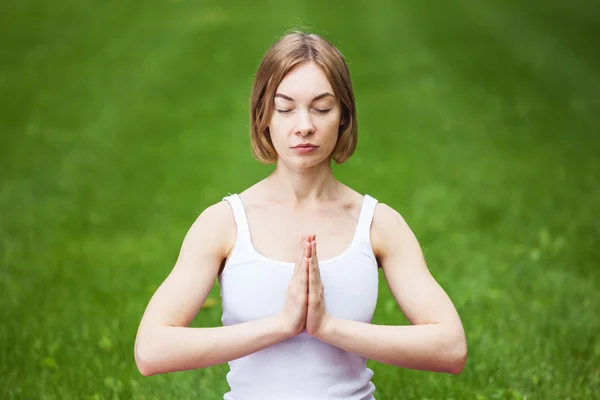 Giovane donna che fa yoga nel parco. — Foto Stock