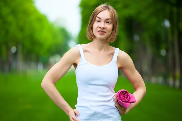 Portret van gelukkig fitness vrouw met yoga mat buitenshuis. — Stockfoto