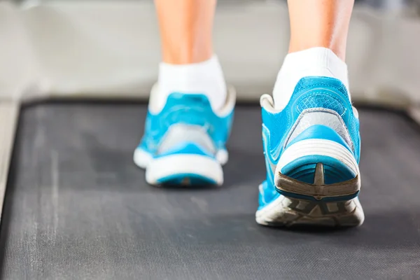 Frau läuft in Turnhalle auf Laufband. — Stockfoto