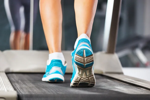 Frau läuft in Turnhalle auf Laufband. — Stockfoto