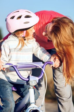 Kızıl saçlı kız Bisiklete binmek kask öğrenme.