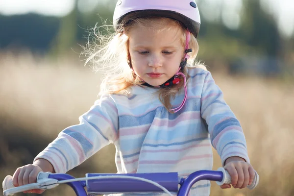 Pequeno garoto engraçado andar de bicicleta com rodas de treinamento . — Fotografia de Stock