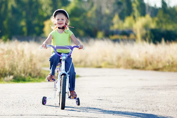 Små roliga barn ridning cykel med stödhjul. — Stockfoto