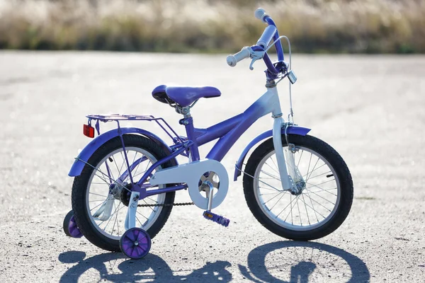 Bicicleta infantil con ruedas de entrenamiento al aire libre . — Foto de Stock