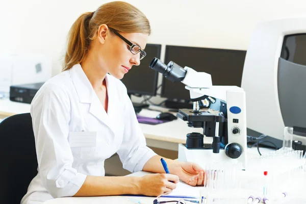 Femme dans un laboratoire travaillant avec des échantillons . — Photo