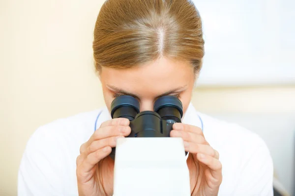 Frau arbeitet mit Mikroskop. — Stockfoto