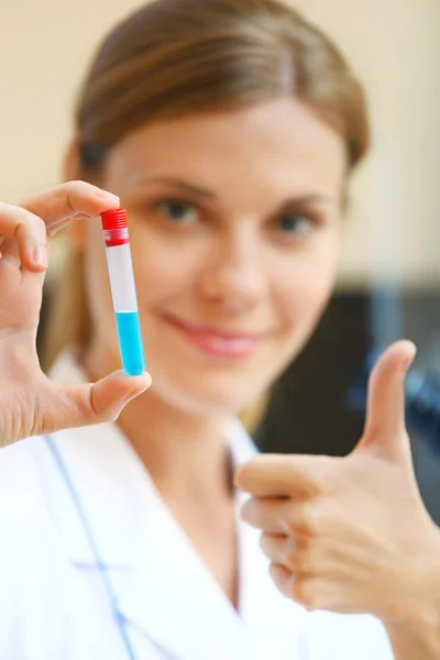 Glückliche junge Wissenschaftlerin hält Proben mit positivem Test in der Hand — Stockfoto