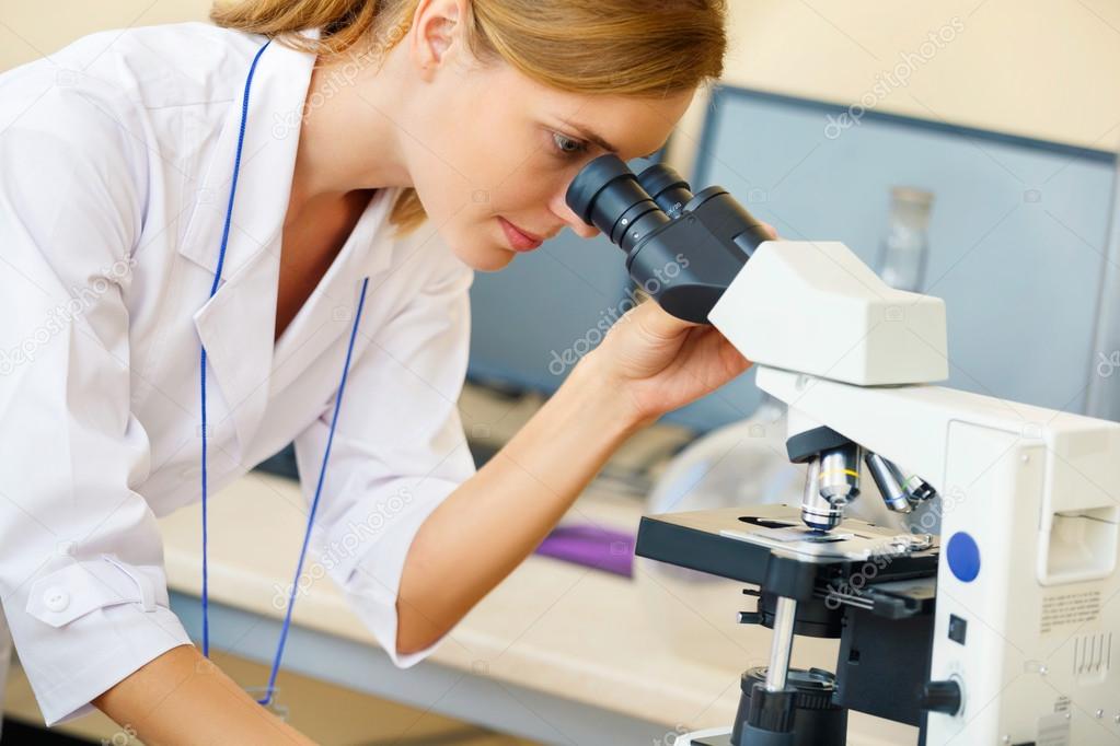 Woman working with a microscope.