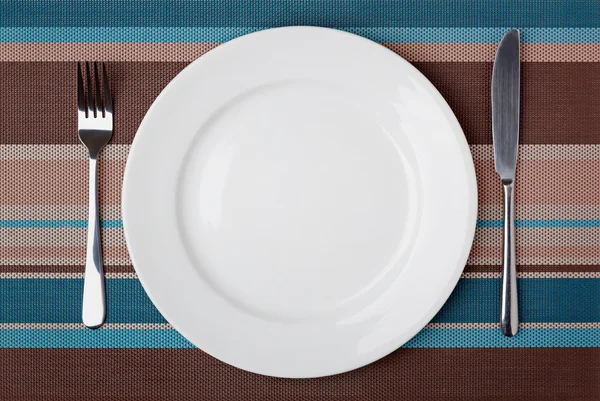 Messer, Gabel und Teller auf dem Tisch. — Stockfoto