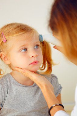 Çocuk doktoru alarak sıcaklık termometre ile.