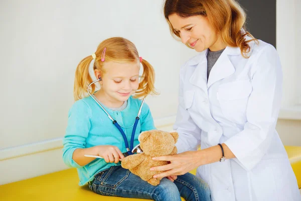 Kinderarzt untersucht kleines Mädchen. — Stockfoto