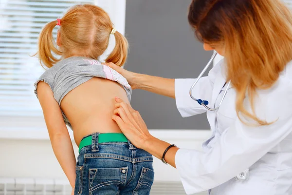 Barnläkare undersöker liten flicka med ryggproblem. — Stockfoto