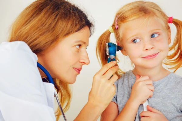 Kinderarzt untersucht Ohren kleiner Mädchen. — Stockfoto