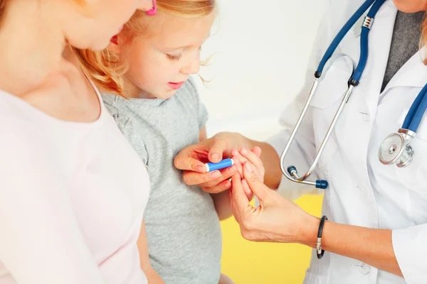 Dokter die een bloedtest doet bij een kleine patiënt. — Stockfoto