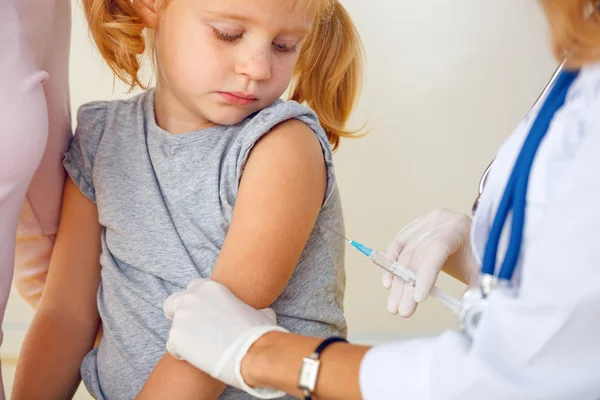 Läkare vaccinerande liten rödhårig Tjej. — Stockfoto