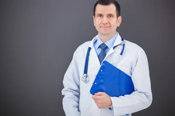 Portrait of confident doctor on gray background looking at the c — Stock Photo, Image