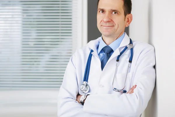 Retrato de médico confiado con las manos cruzadas mirando la c — Foto de Stock