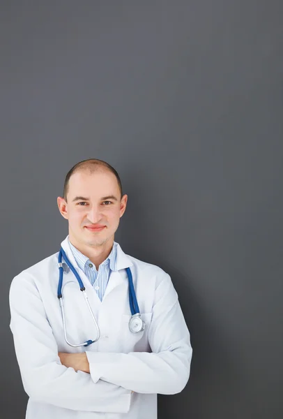 Portrait of confident doctor on gray background looking at the c — Stock Photo, Image