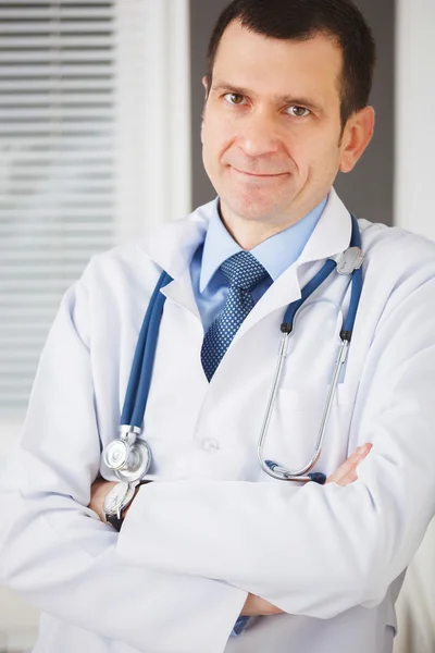 Retrato de médico confiado con las manos cruzadas mirando la c — Foto de Stock