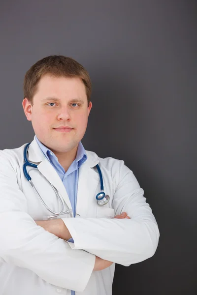 Portrait of confident doctor on gray background looking at the c — Stock Photo, Image