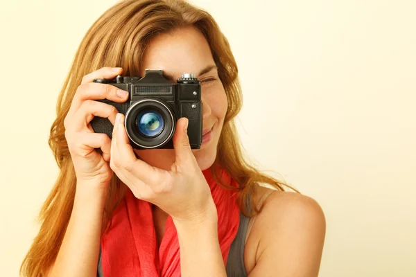 Mujer pelirroja joven mirando a través del visor con un viejo 35mm — Foto de Stock