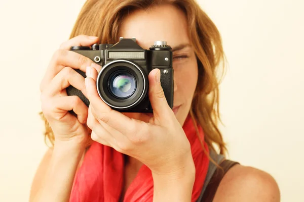 Mujer pelirroja joven mirando a través del visor con un viejo 35mm —  Fotos de Stock