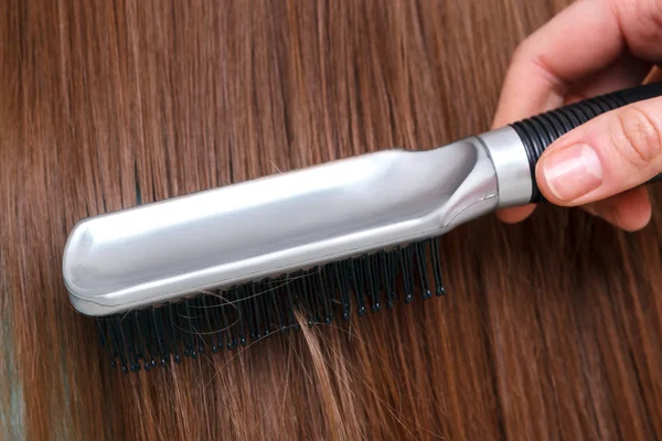 Hand with comb and hairs closeup. — Stock Photo, Image