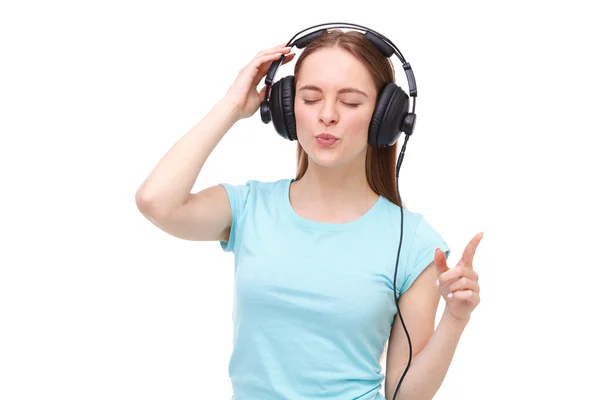 Mujer joven con auriculares escuchando música y bailando - aislada . — Foto de Stock